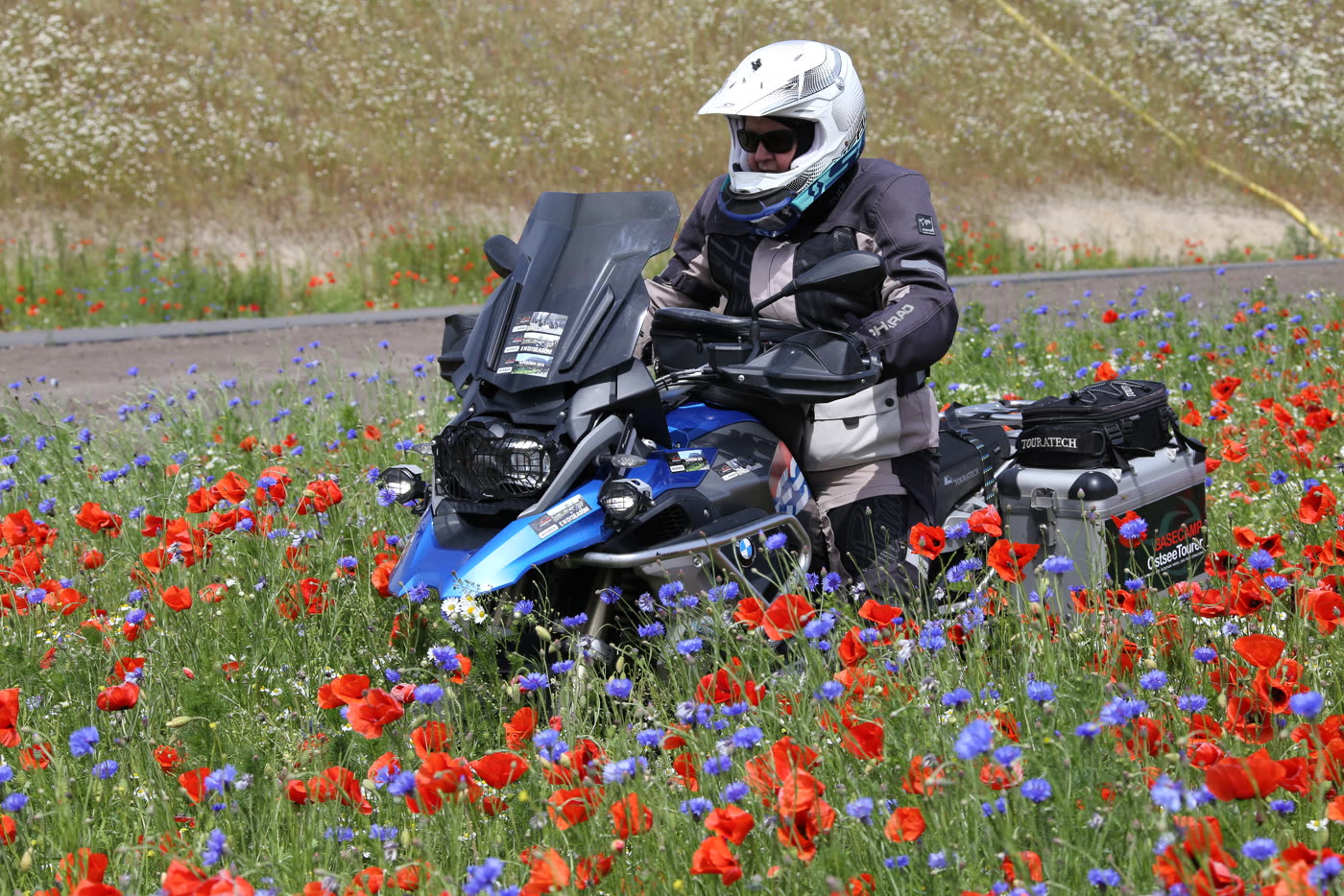 Motorrad auf der Landstraße neben leuchtend rotem Mohn Motorrad auf der Landstraße neben leuchtend rotem Mohn